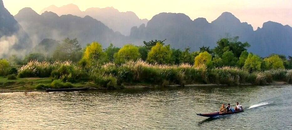 Pirogue à moteur naviguant sur la rivière Nam Song qui traverse la région de Vang Vieng