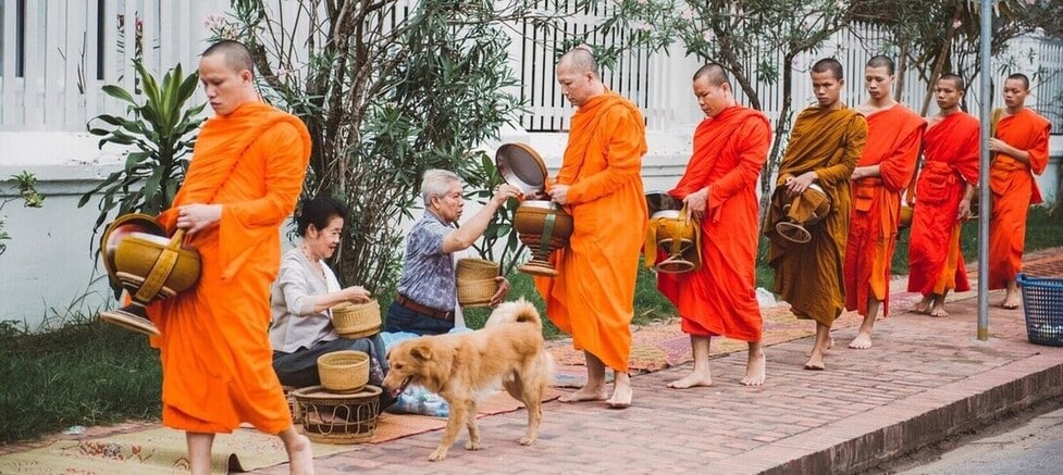 La cérémonie du Tak Bat au lever du jour dans les rues de Luang Prabang